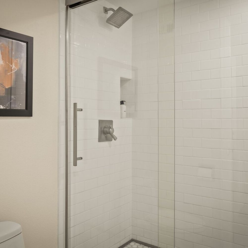The bathroom has a walk-in glass shower