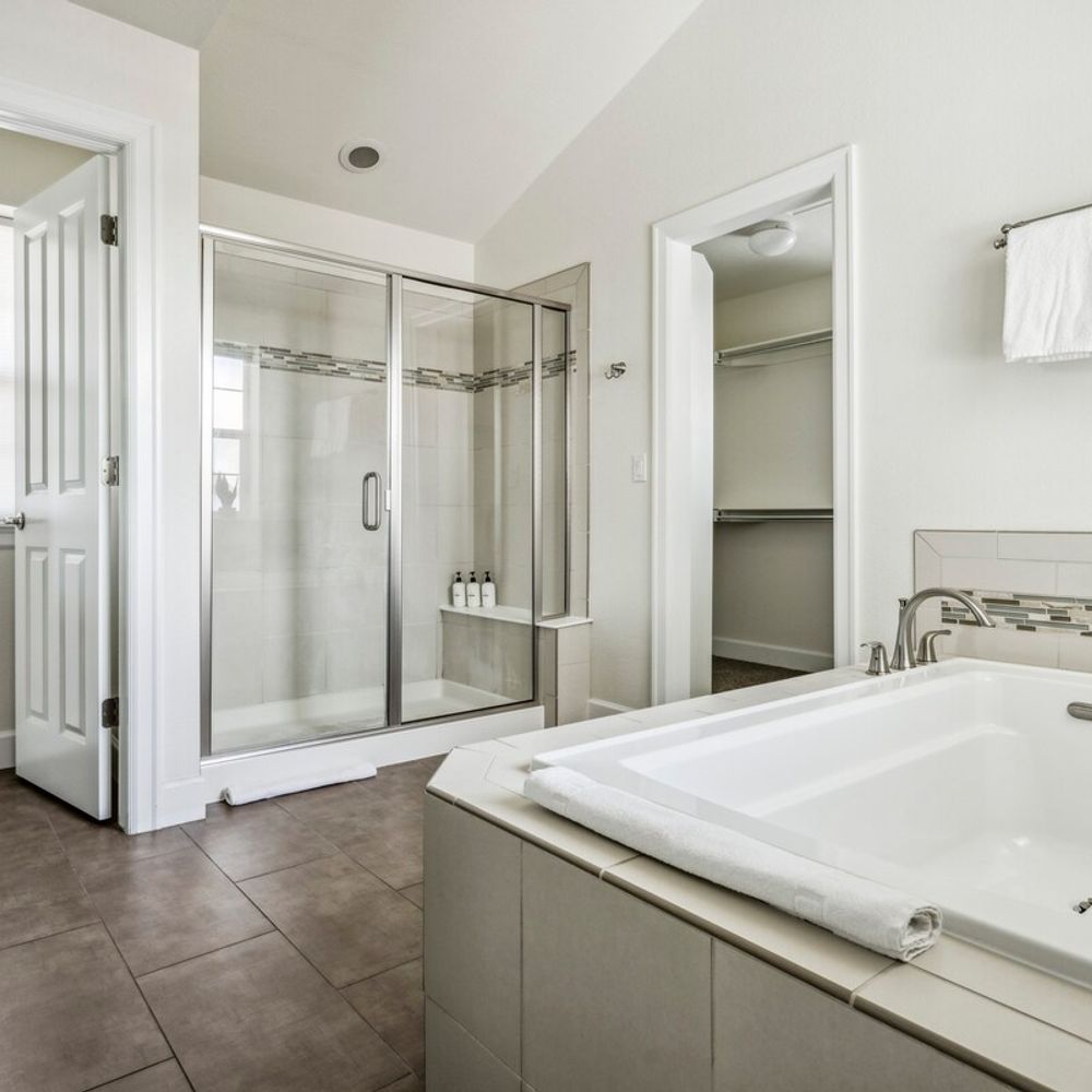 Primary en suite bathroom with shower and soaking tub