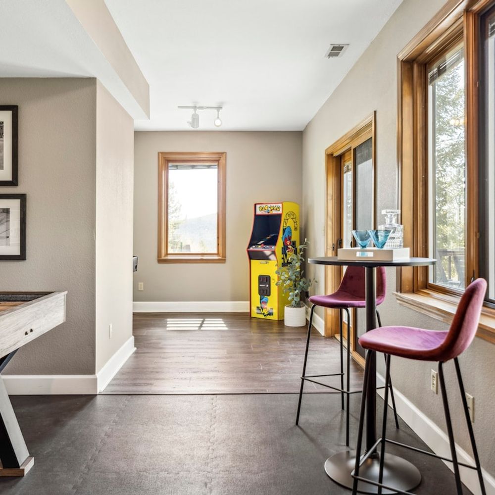 Game room with a tabletop shuffleboard and arcade machine