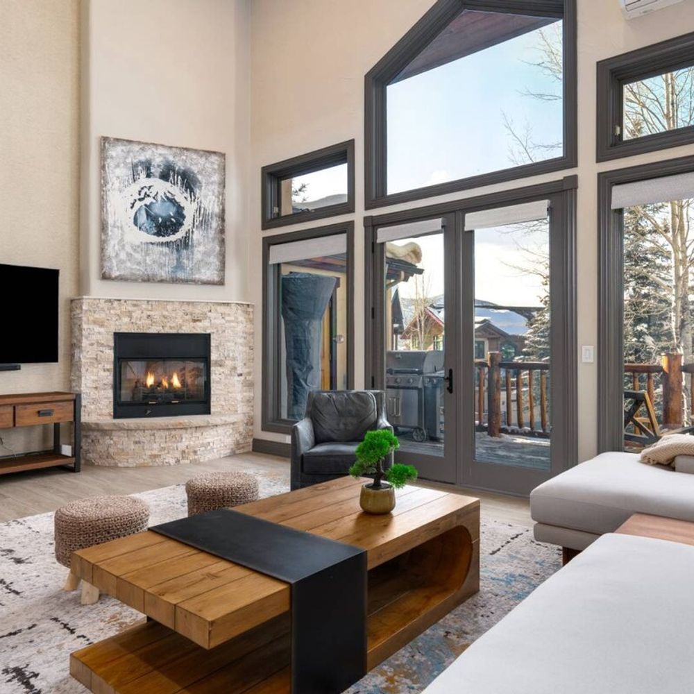 Living area view of balcony, fireplace, and TV