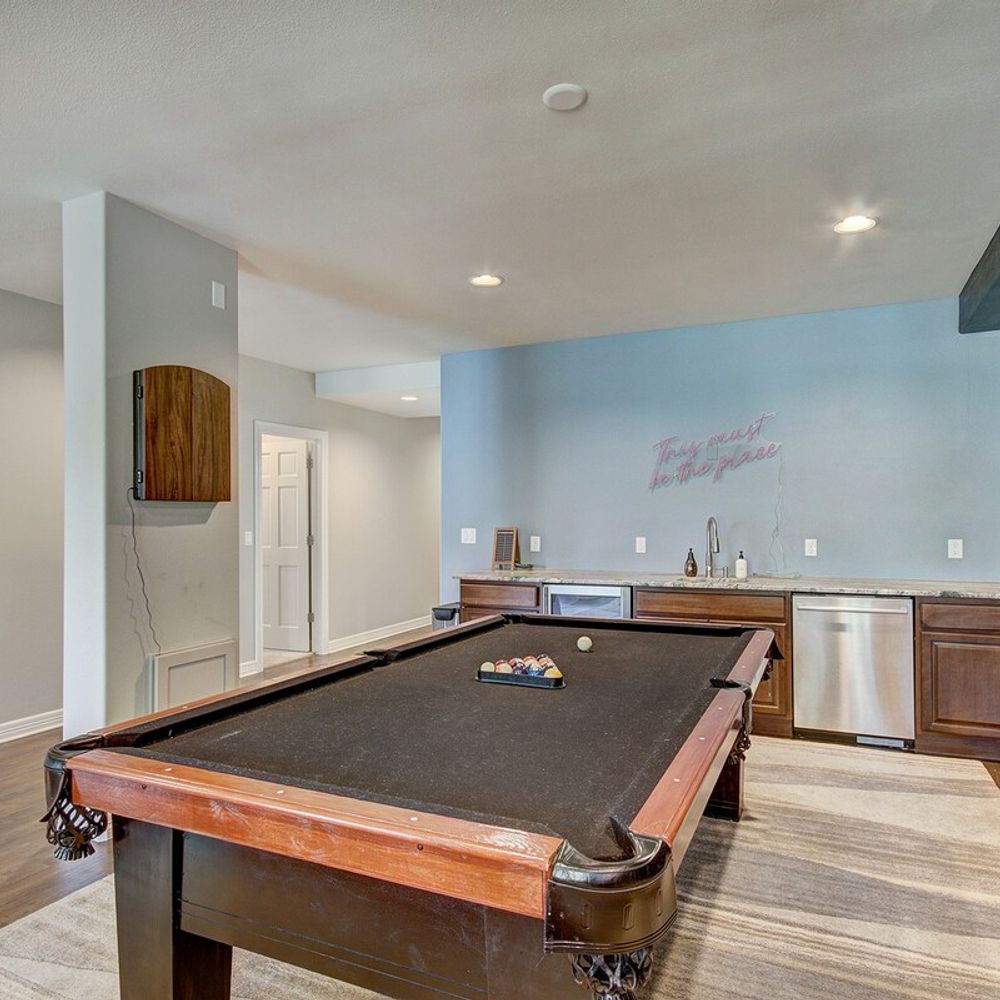 Pool table and wet bar in game room on lower level