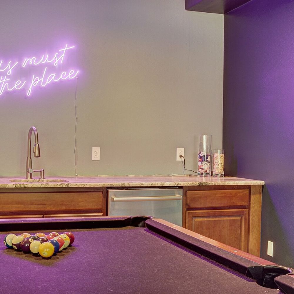 Pool table and neon sign in game room