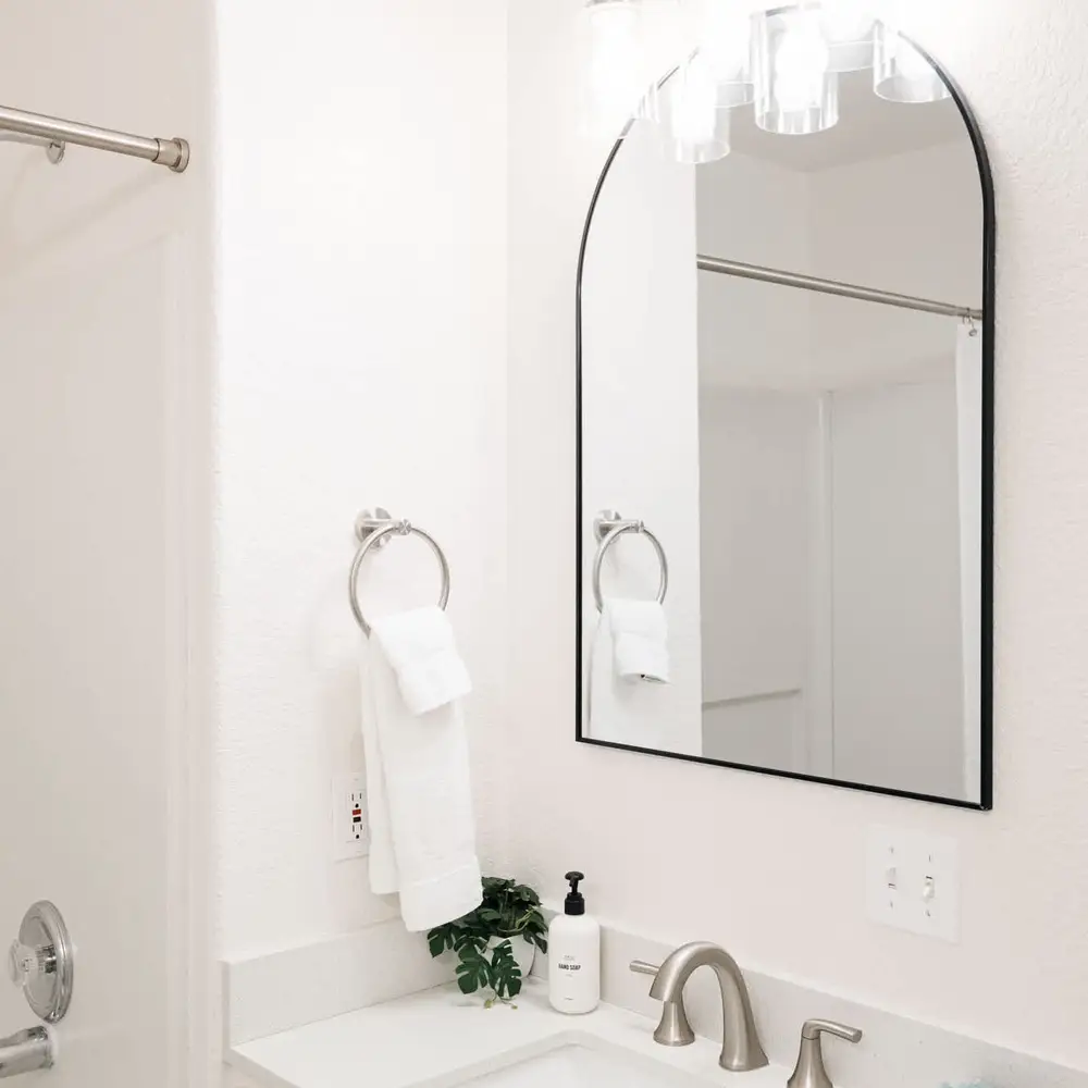 Primary bedroom's full & private ensuite bathroom with dual vanities and a tub/shower combo