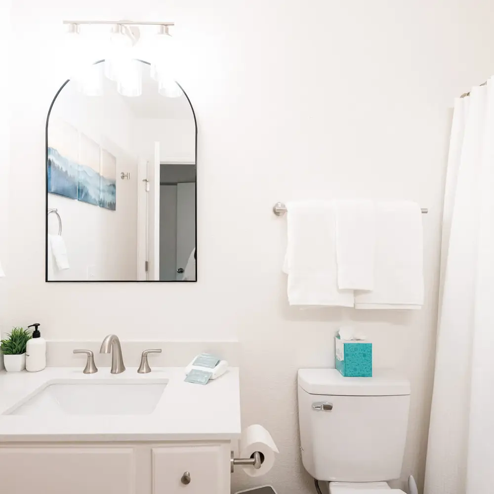 Primary bedroom's full and private ensuite bathroom with dual vanities and a tub/shower combo