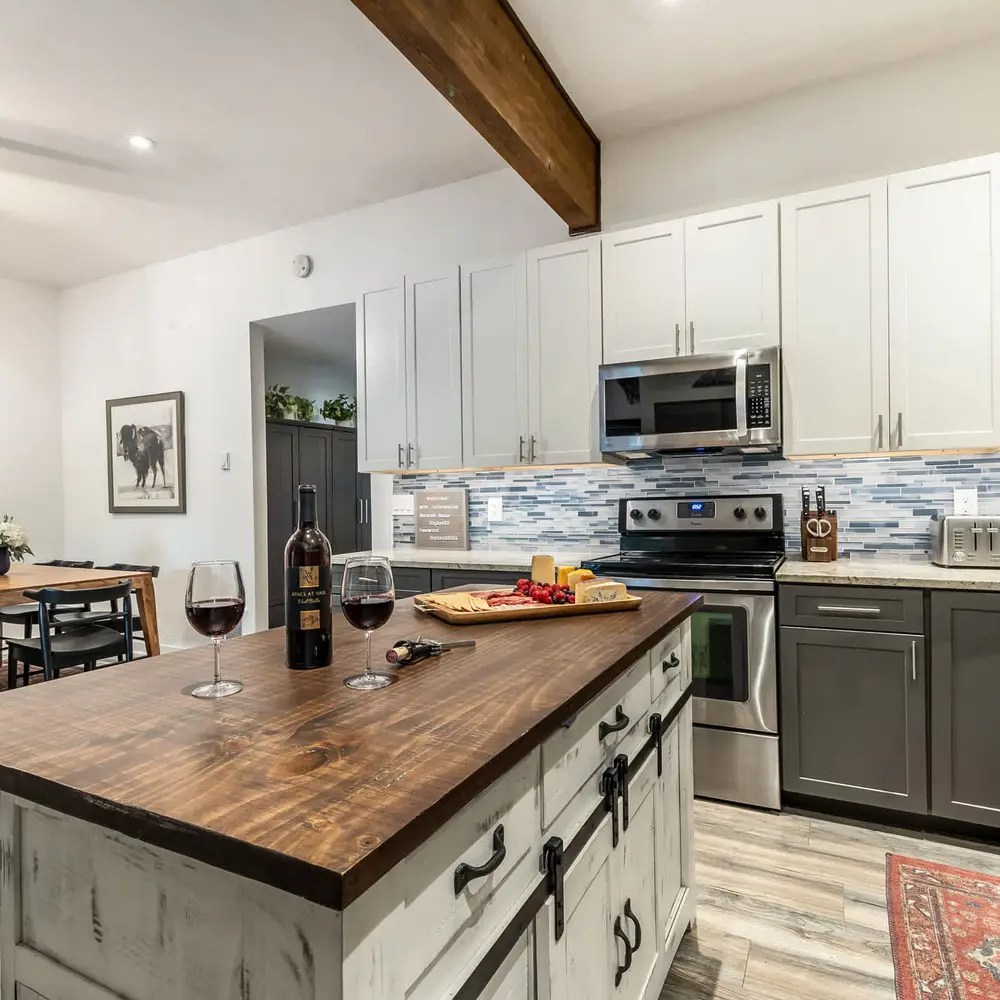 Open kitchen with island seating and dining table (charcuterie board and wine, not included)