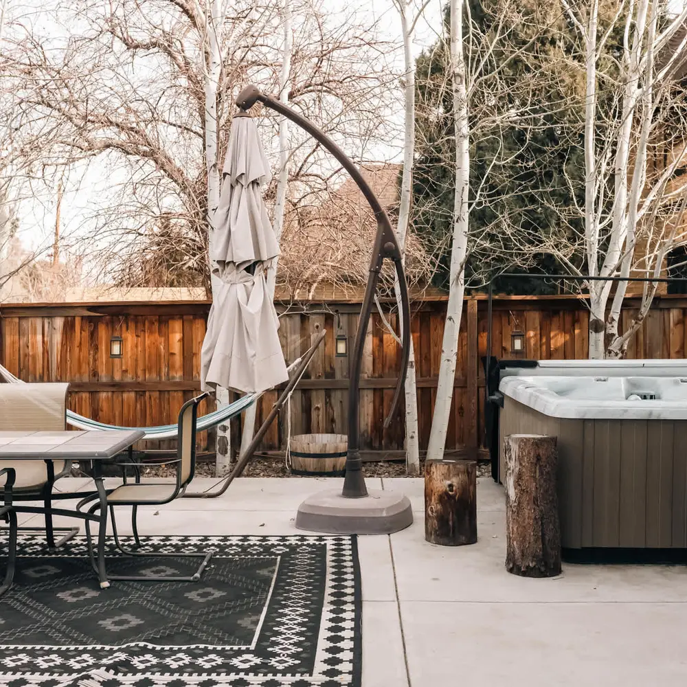 Patio with private hot tub and seating *Please note: The umbrella is not available for guest use.*