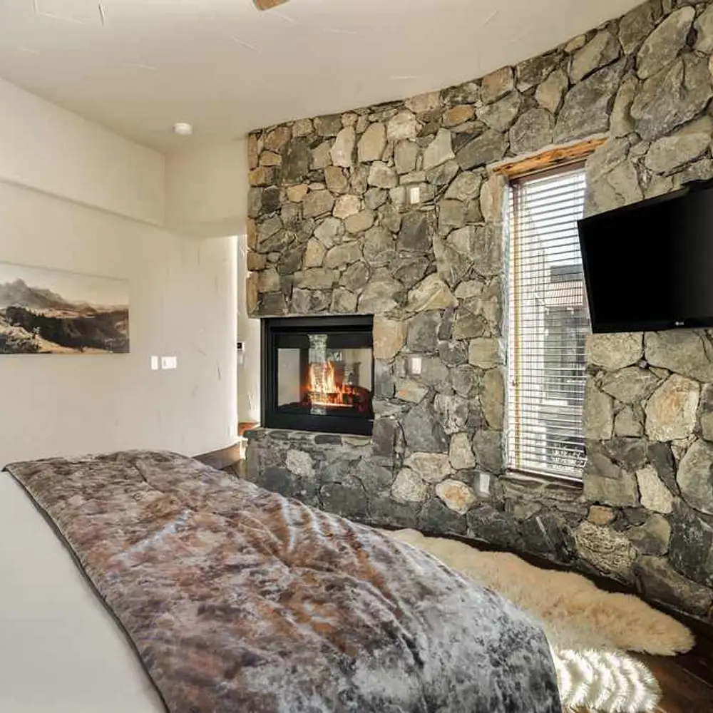 Primary bedroom with a king bed, a flatscreen TV, and a gas fireplace