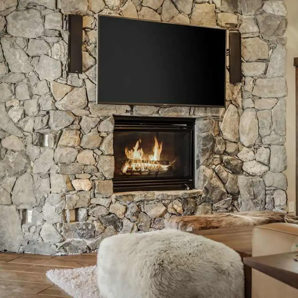 Second-level living area with a gas fireplace, flatscreen TV, and balcony exit