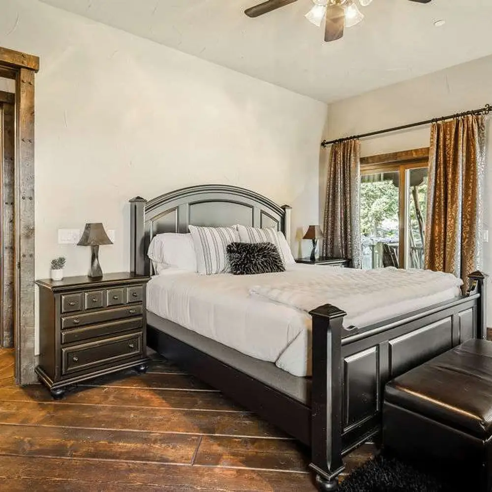 Bedroom 2 with a king bed, a flatscreen TV, balcony exit, and a private full ensuite bathroom