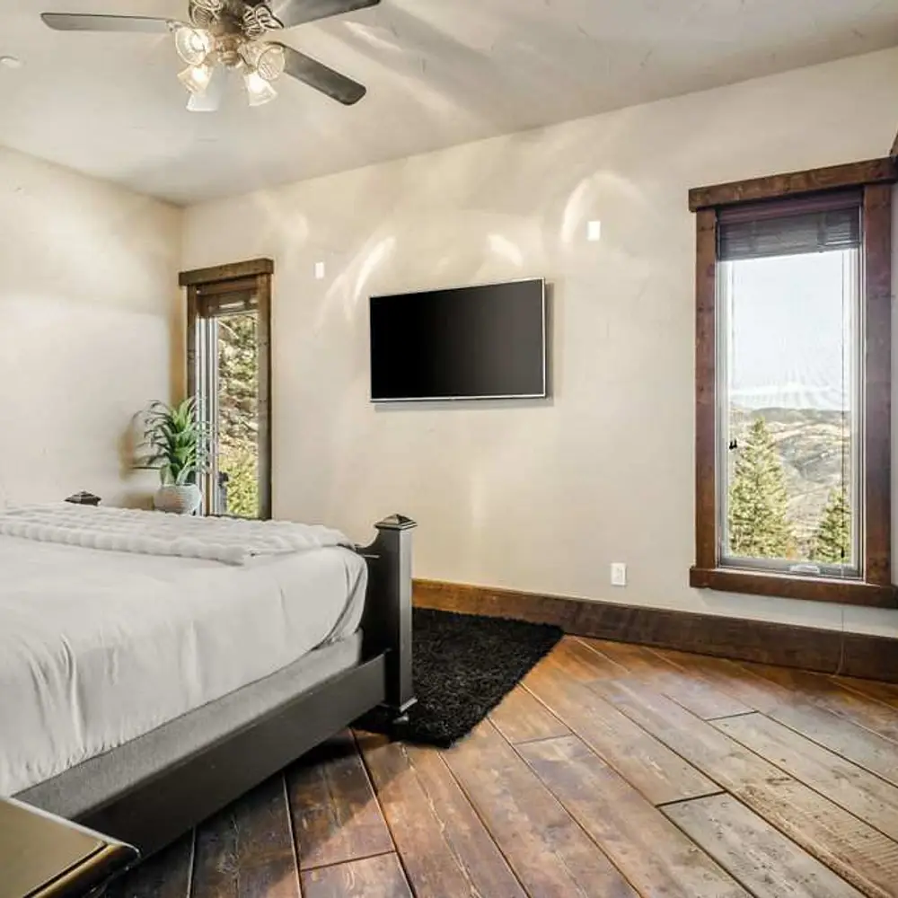 Bedroom 2 with a king bed, a flatscreen TV, balcony exit, and a private full ensuite bathroom