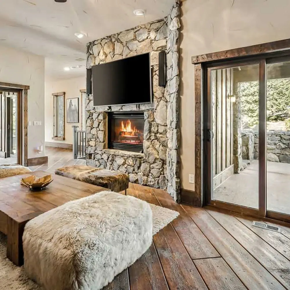 Second-level living area with a gas fireplace, flatscreen TV, and balcony exit