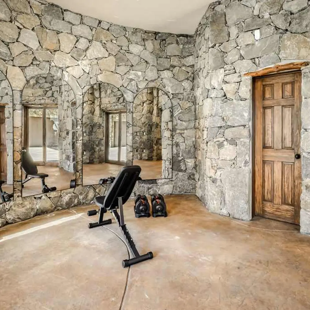 On-site private gym with workout equipment, flat screen TV, and private half bath