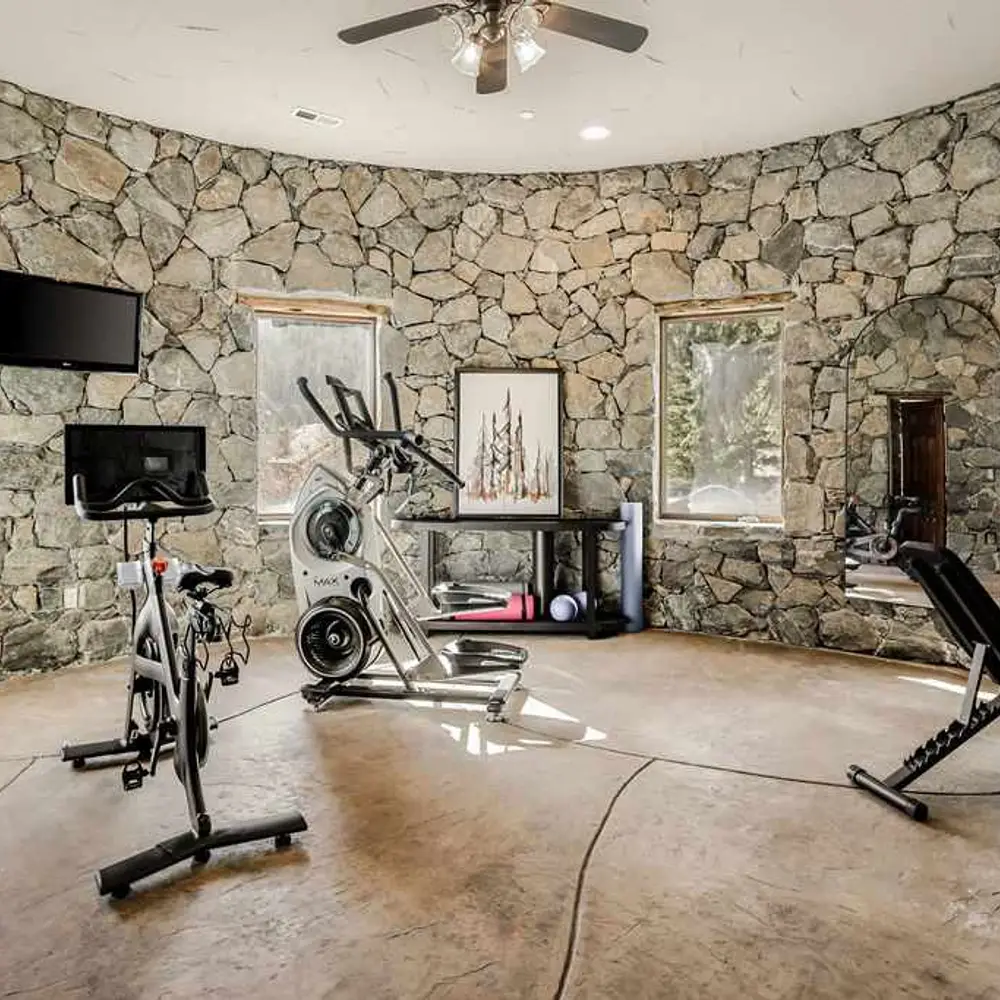 On-site private gym with workout equipment, flat screen TV, and private half bath