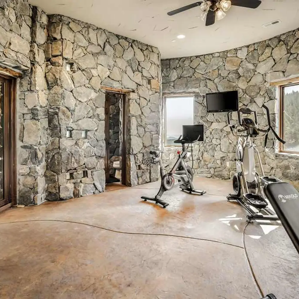 On-site private gym with workout equipment, flat screen TV, and private half bath