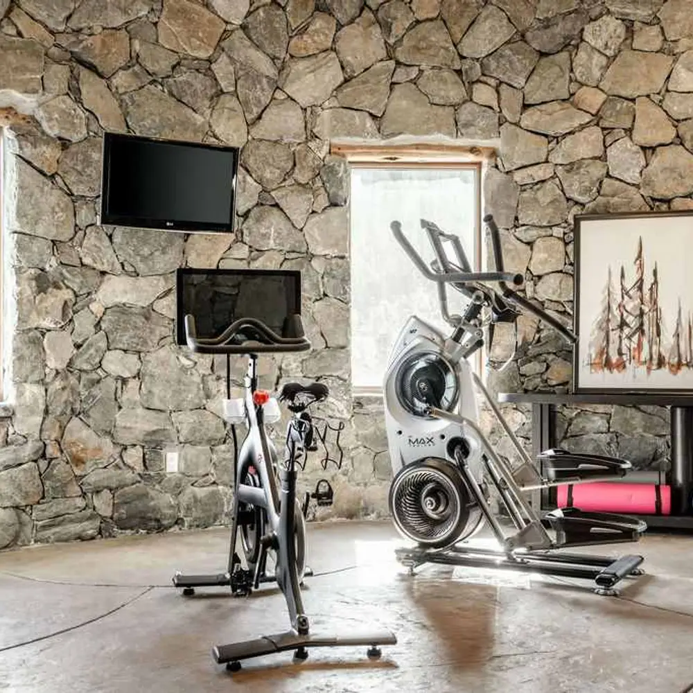 On-site private gym with workout equipment, flat screen TV, and private half bath
