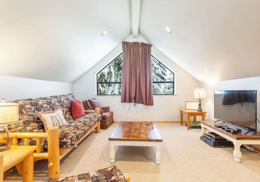The second, loft living room with futon, TV and Xbox.