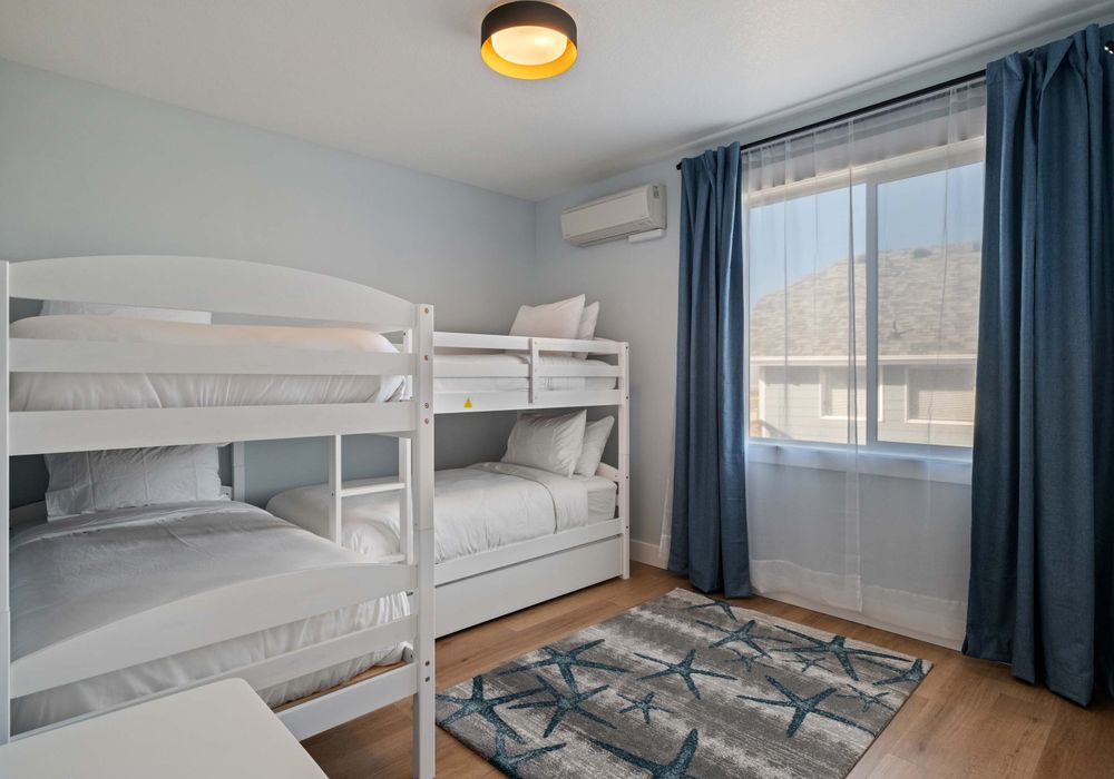 Bunk room has soft rugs, extra light, and plenty of room for games or bags.