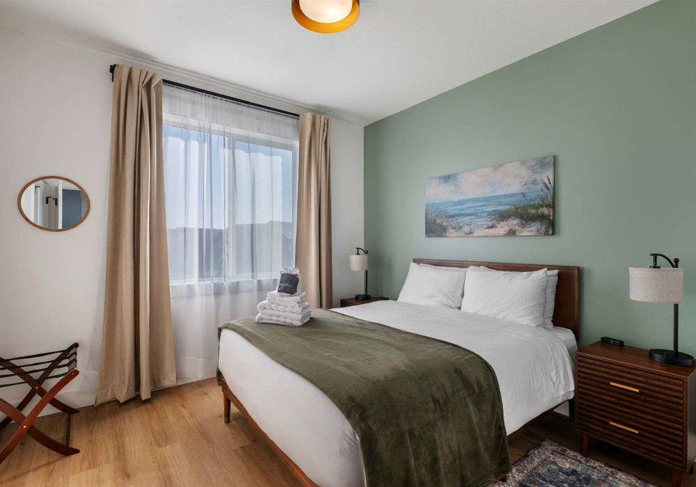 Second queen bedroom with relaxing colors and natural light.