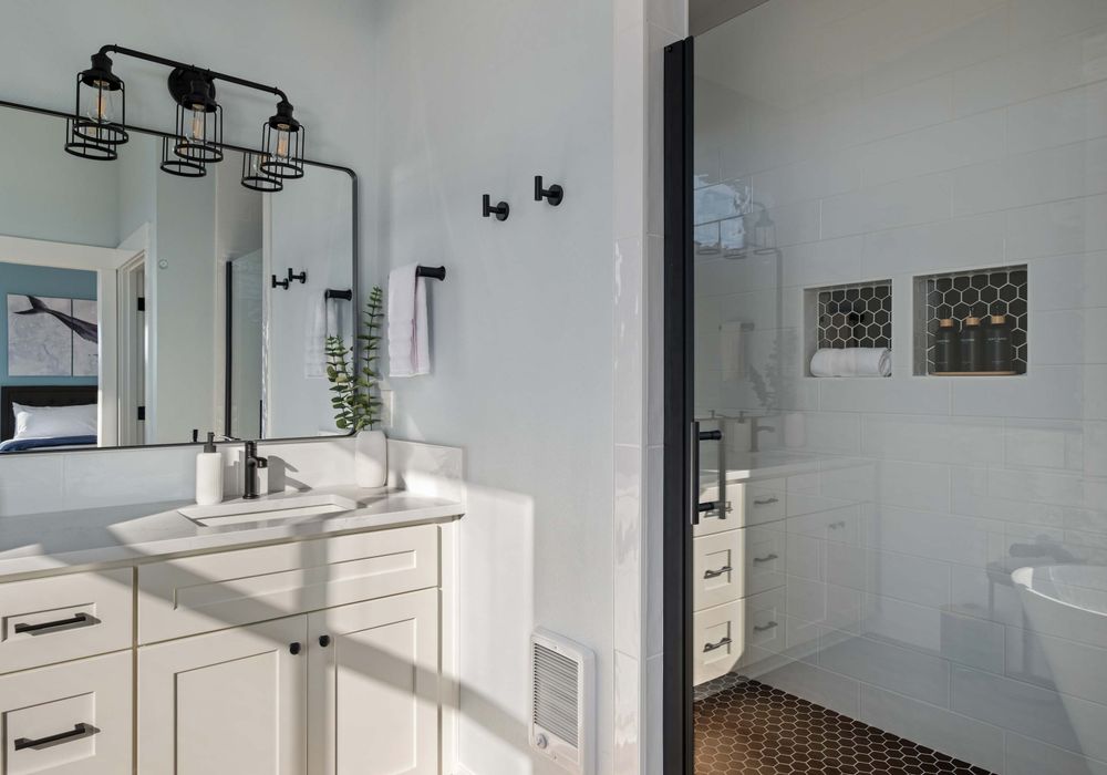 Large shower, two sinks, and clean finishes—shared by two of the bedrooms.