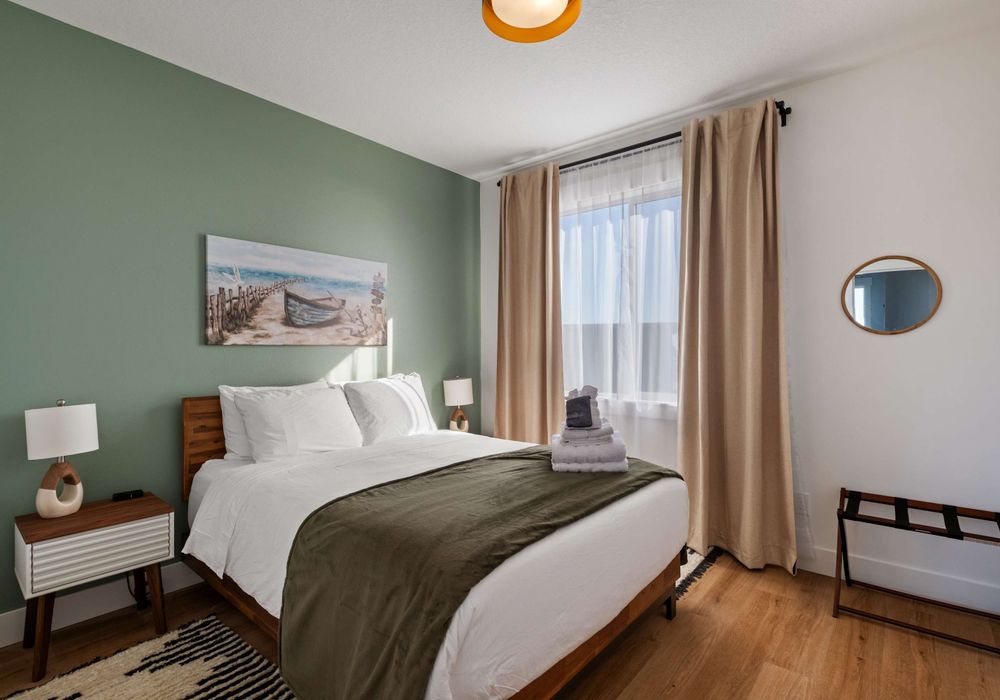 Comfortable queen bedroom with light-blocking curtains and modern design.