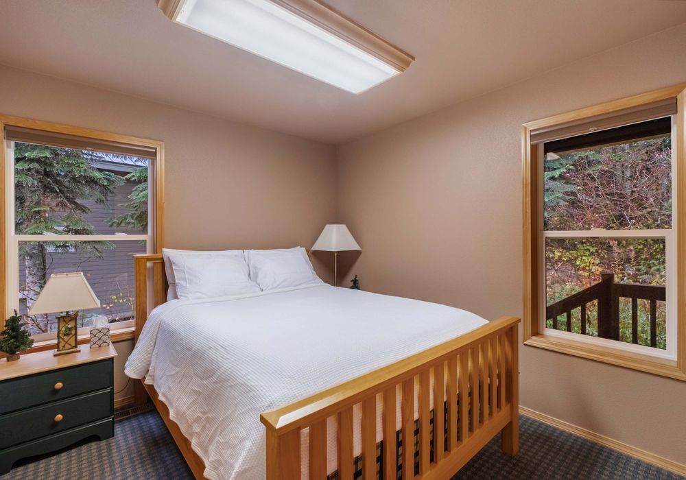 A spacious, restful bedroom with a queen-sized bed and dreamy, soft bedding invites you to sleep in, lounge around, and truly unwind in style.