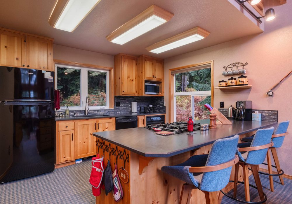 A spacious kitchen with a functional kitchen bar provides extra seating and space to enjoy meals or chat while cooking.
