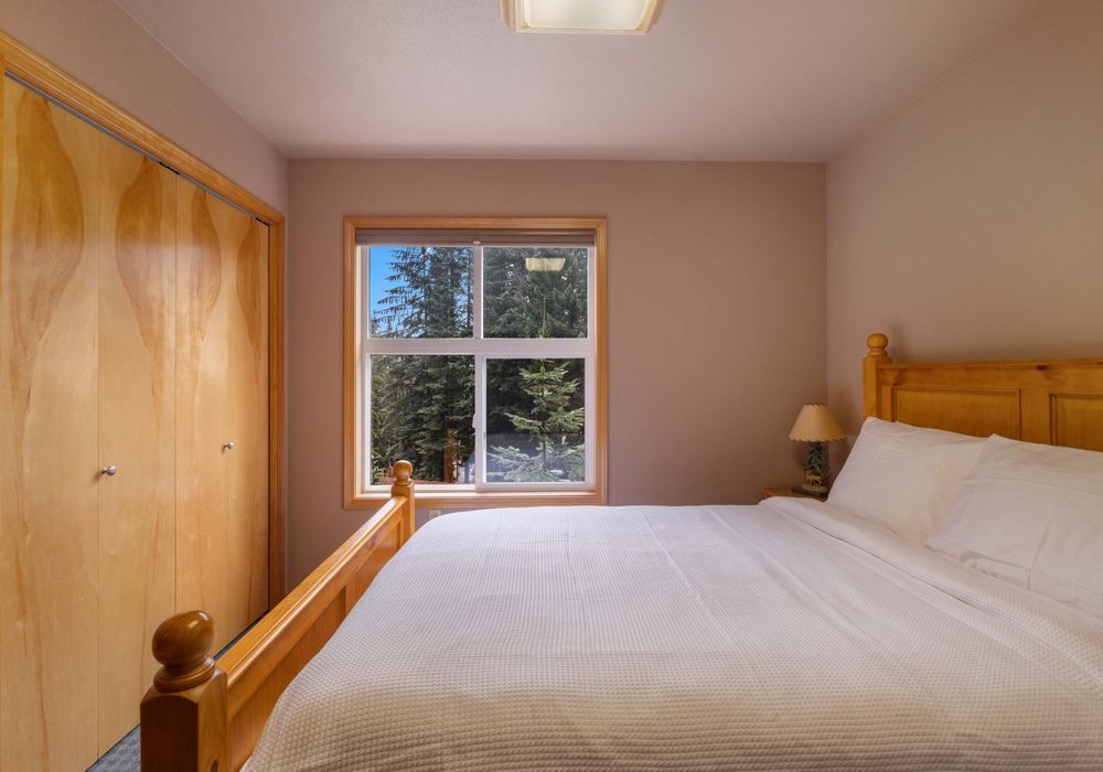 A spacious, restful bedroom with a queen-sized bed and dreamy, soft bedding invites you to sleep in, lounge around, and truly unwind in style.