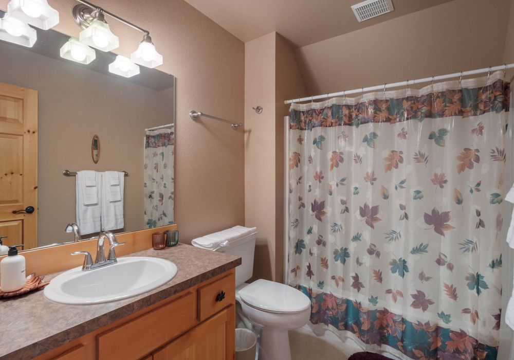 A cozy bathroom with a wooden sink vanity and natural accents, offering a calming, earthy vibe to complement modern amenities.