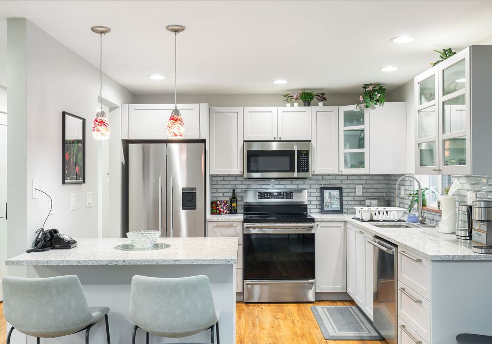 A clean, modern kitchen with a counter and stools, perfect for casual gatherings or quick meals.