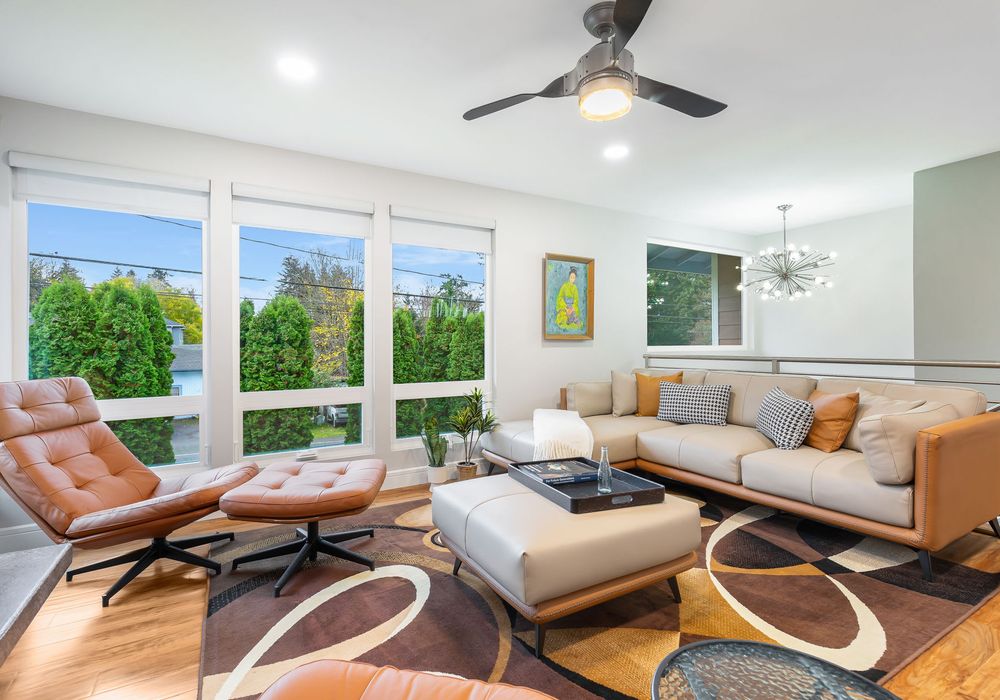 Spacious living room flooded with natural light and framed by picturesque tree views.