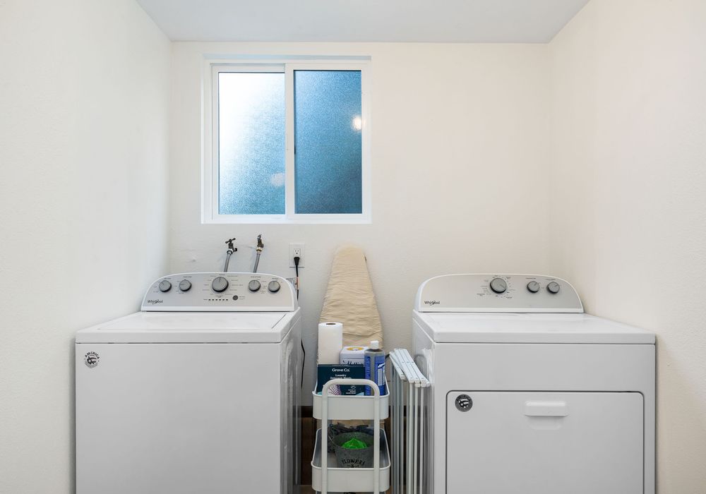 The laundry area is equipped with a modern washing machine and a selection of detergents for your convenience.