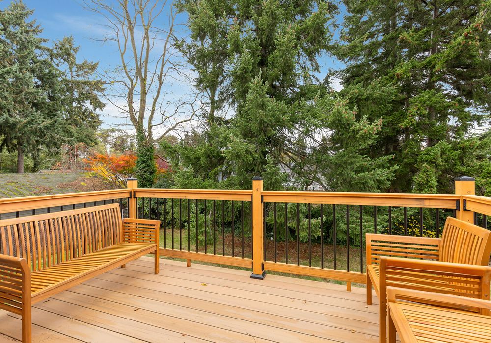Relax on our cozy veranda, furnished with wood chairs, and take in the tranquil view of verdant green trees.