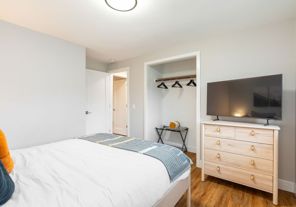 Enjoy entertainment in this bedroom with a TV, while the built-in hangers provide simple and effective clothing storage.