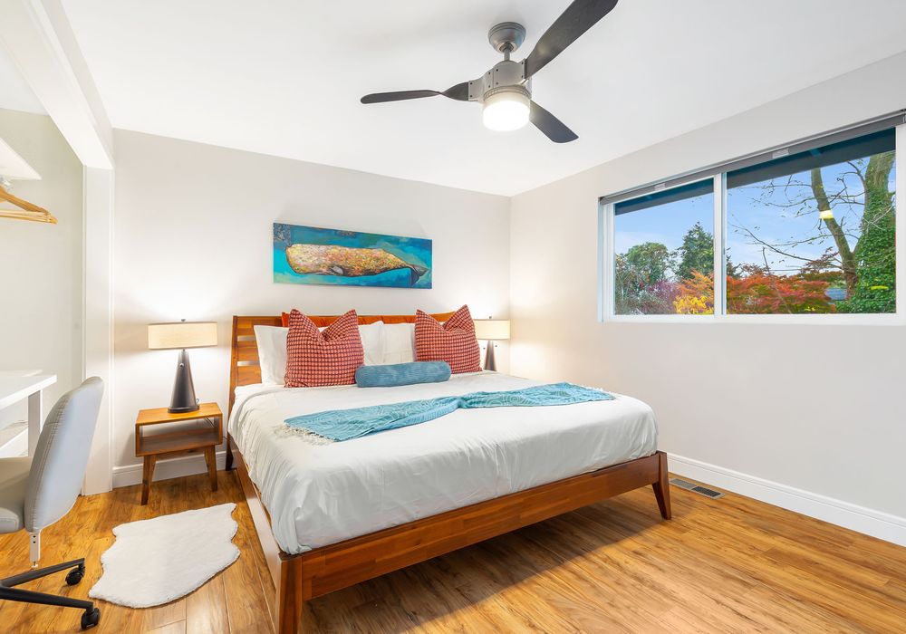 This serene bedroom exudes calm vibes, featuring soft decor and a stylish table for added functionality.