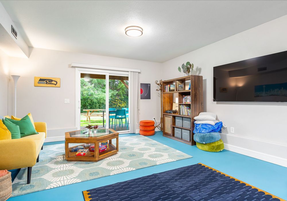 A perfect spot with fireplace for unwinding, offering a collection of games, a TV for movie nights, and shelves filled with books.