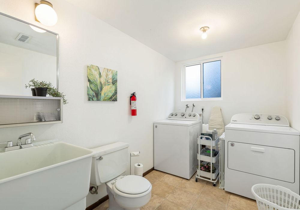A spacious bathroom with a discreet laundry area, designed to make household chores easy and accessible.