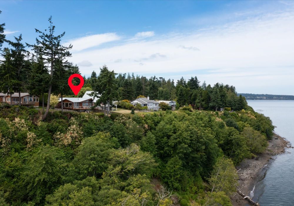 The home sits on a bluff above the Sound,. The beach is right below, access is a few minutes walk away.