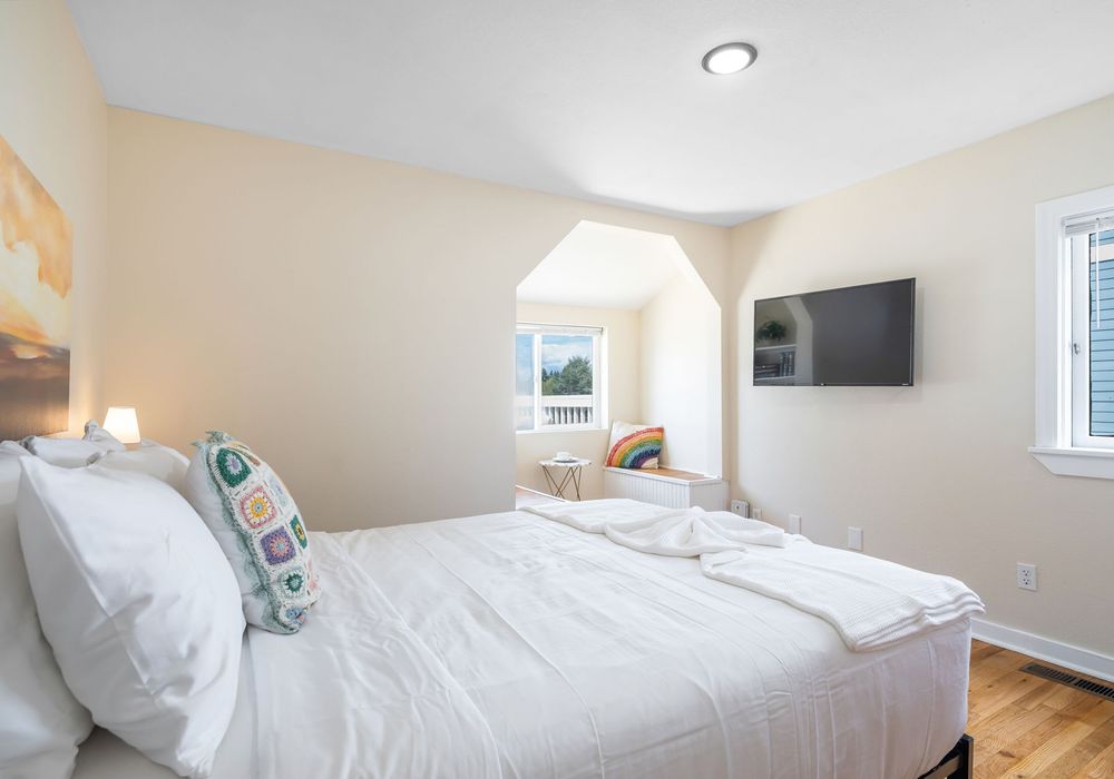 Primary bedroom with bright windows and cozy nook.