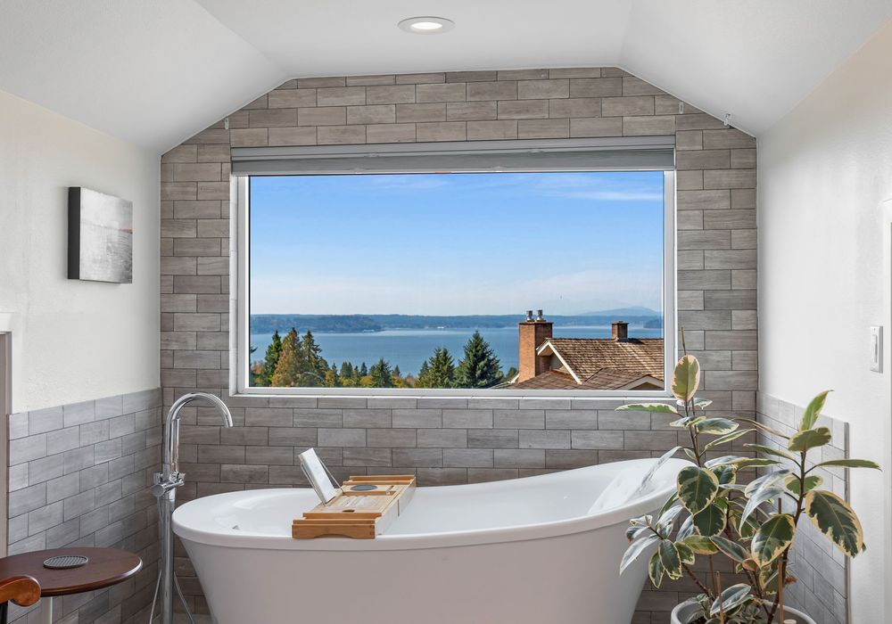 Soak in pure bliss—unwind in a luxurious tub with serene views through a picture-perfect window.
