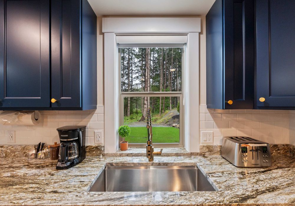 Do the dishes with a view—bright, airy sink space facing lush outdoor scenery.