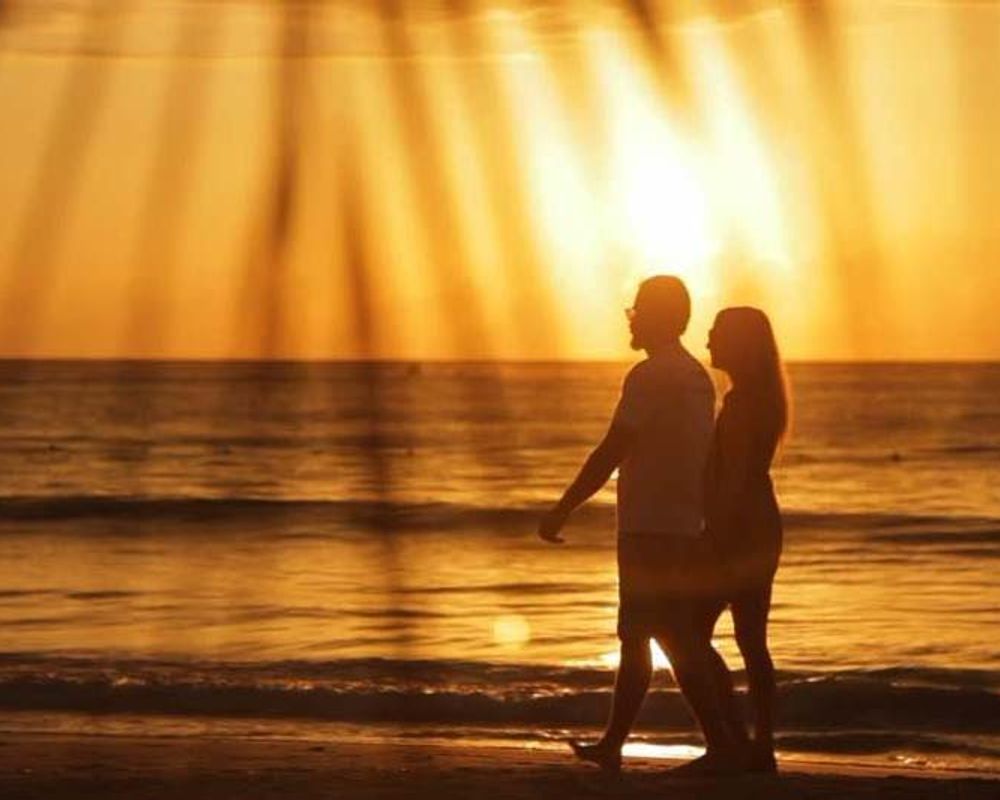 couple on a beach with a sunset