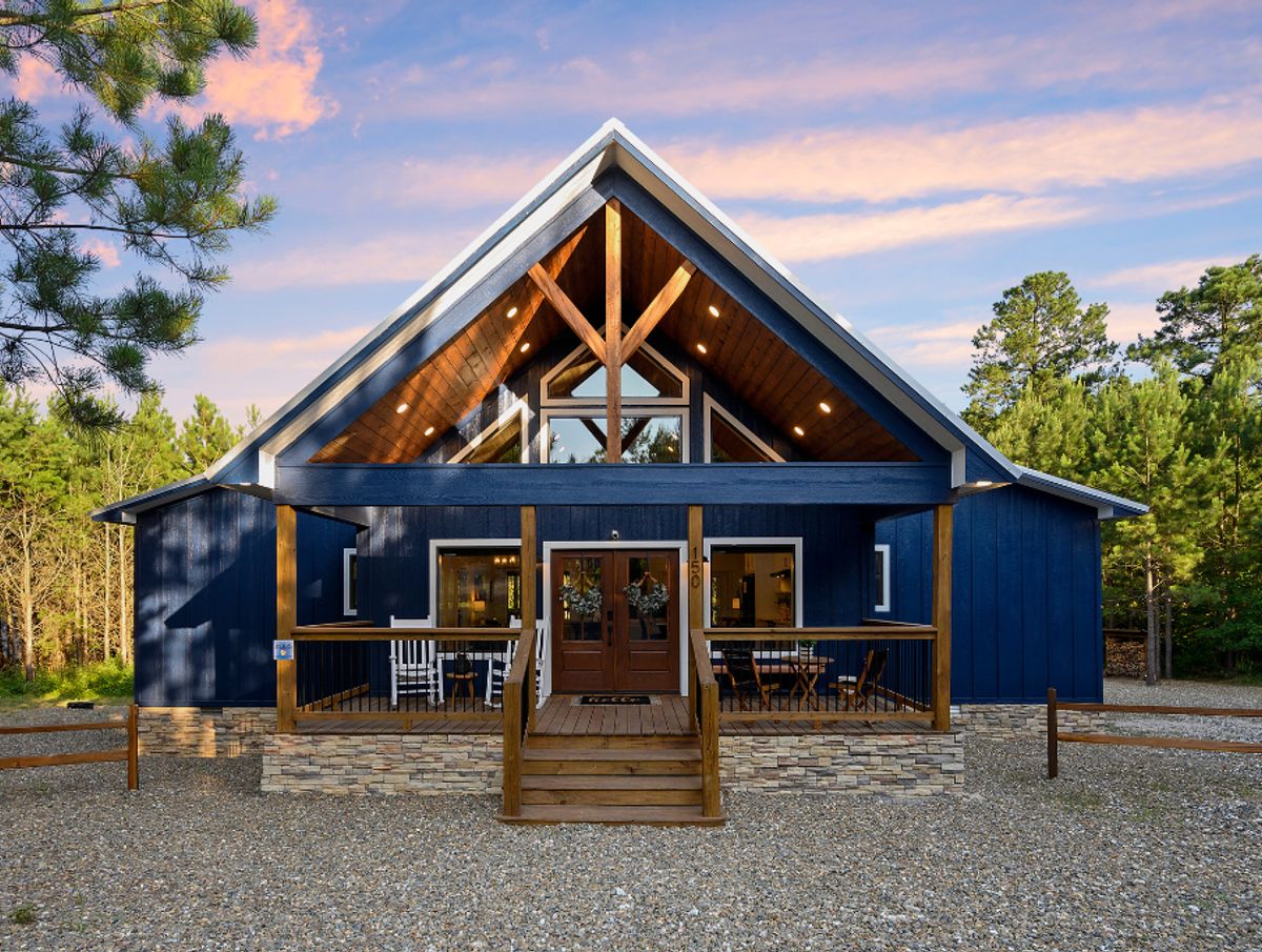 Bluebird Sky cabin exterior featuring a blue and wood facade, a porch with seating
