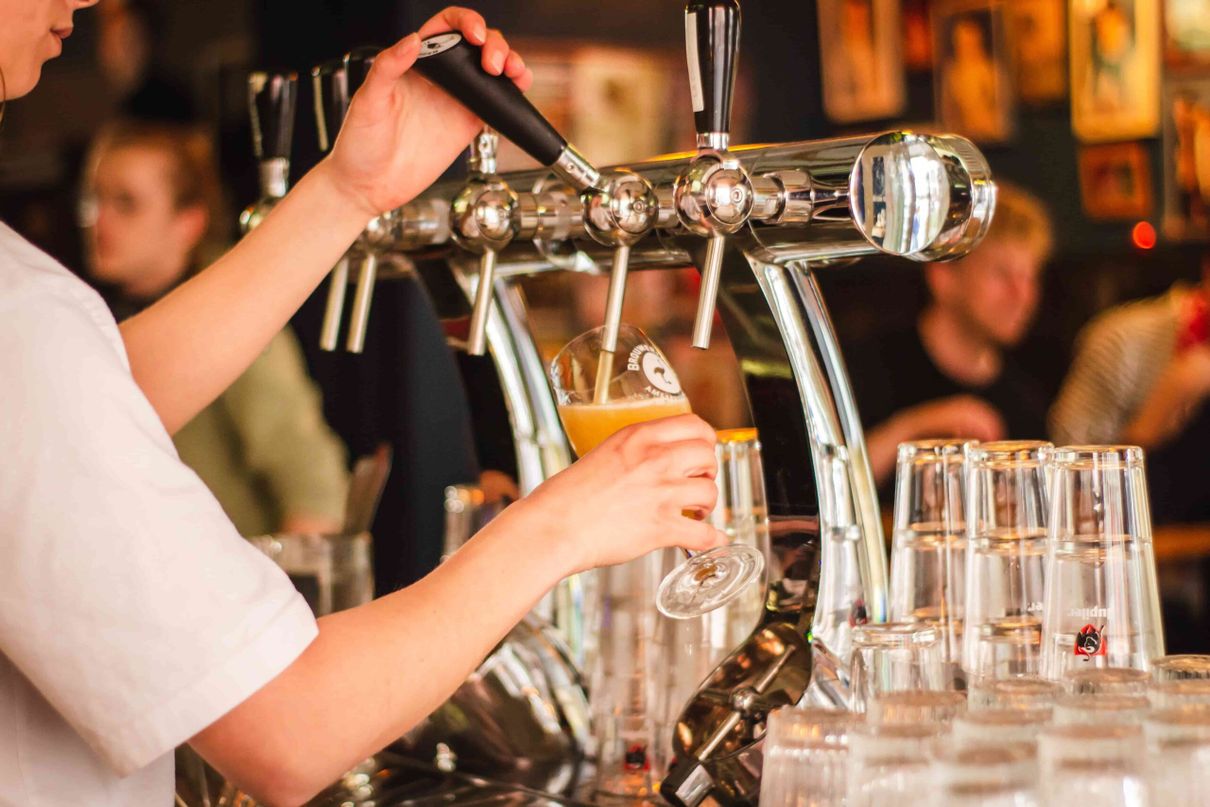 Person pouring a craft beer in Seattle, capturing the essence of the city's vibrant brewery culture, perfect for guests of Seattle vacation rentals.