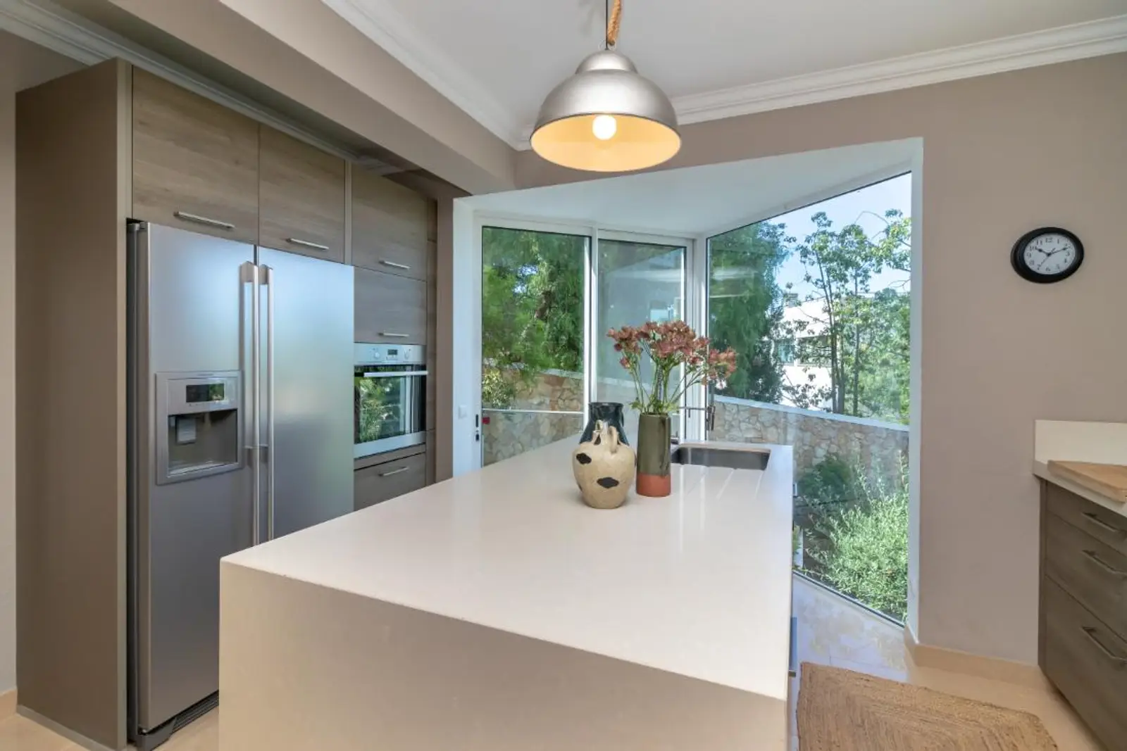 Kitchen island with integrated oven and American-style fridge freezer
