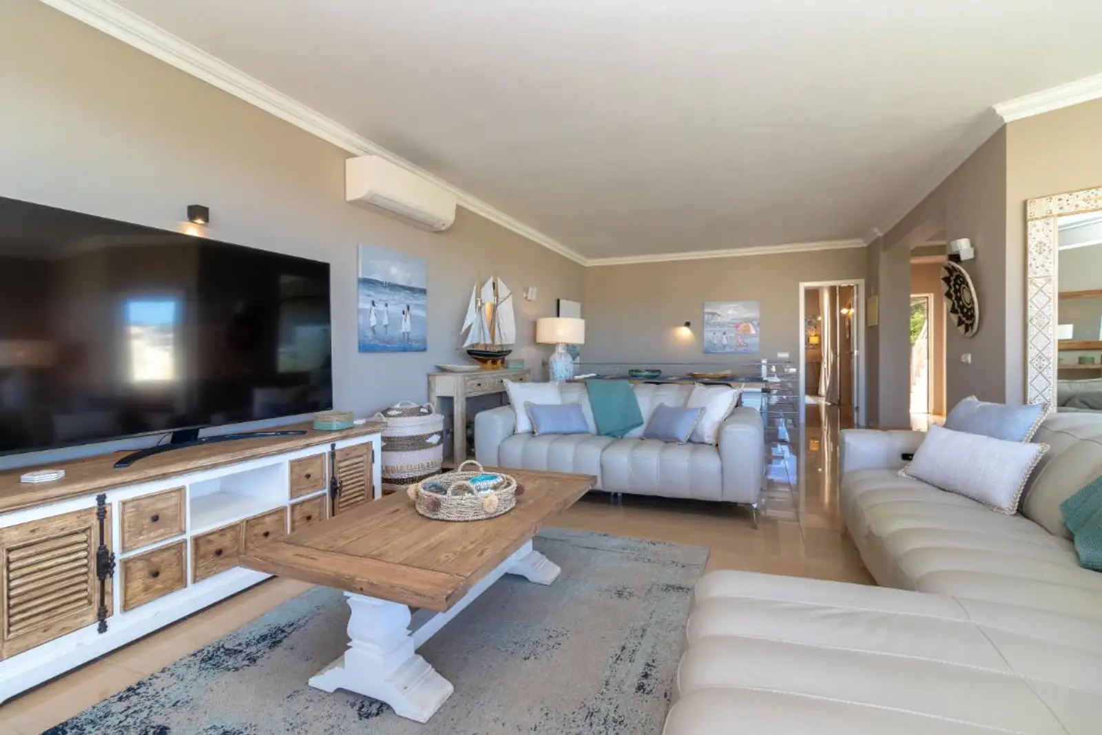 Living room with corner sofa, coffee table and wall-mounted television