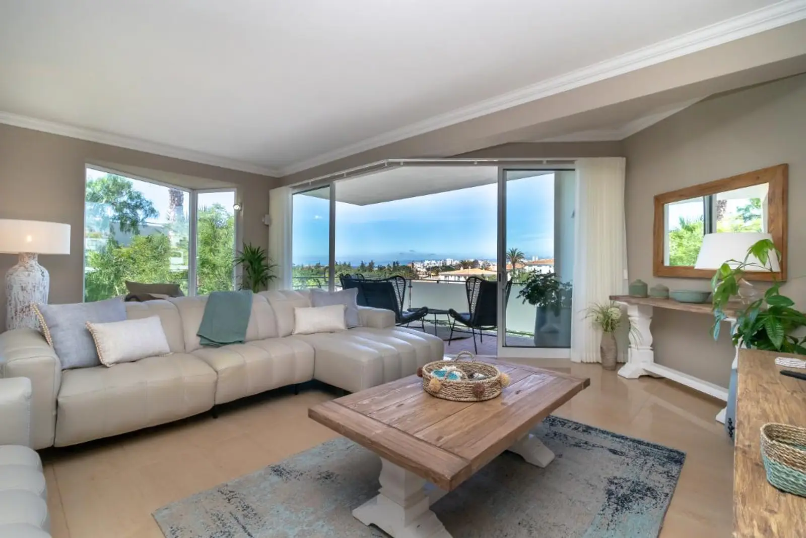 Living room with full-width sliding doors open to the terrace and sea view