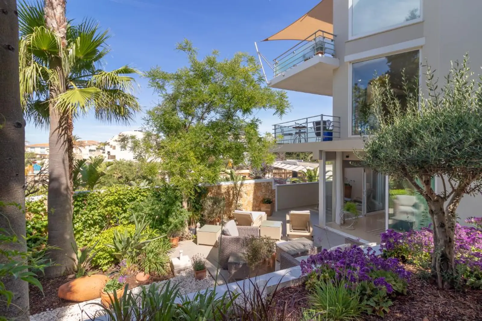 Landscaped grounds with palms looking back at the apartment building