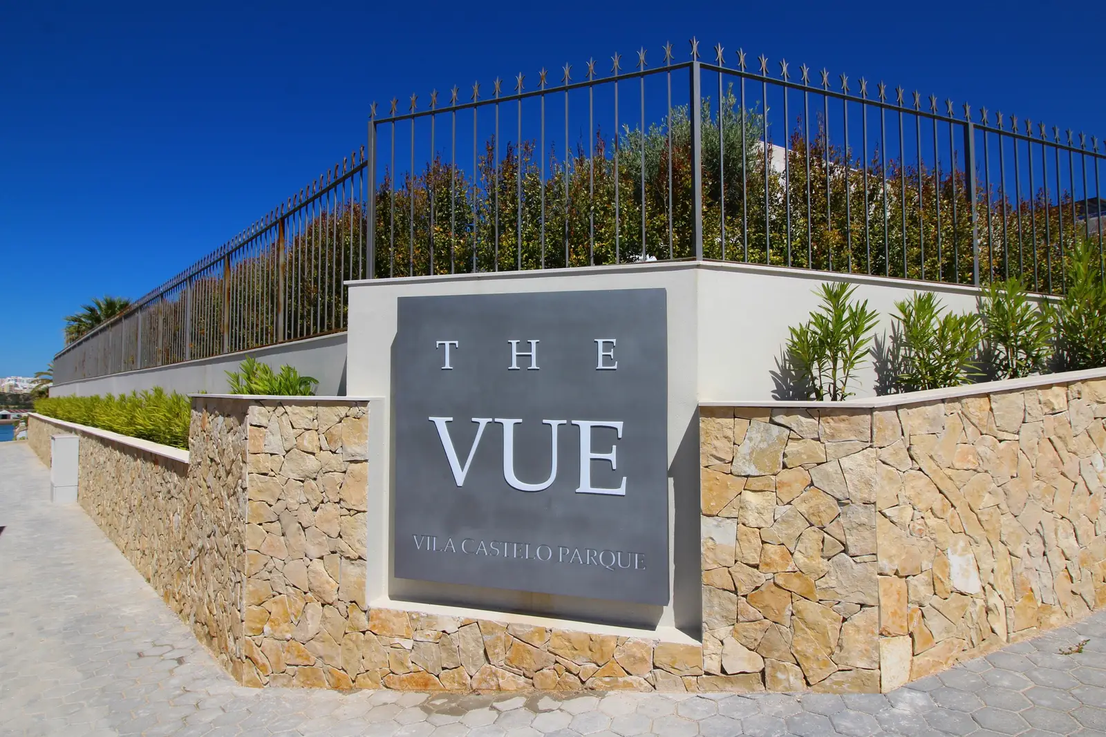 Stone-clad entrance wall with The Vue sign at Vila Castelo Parque