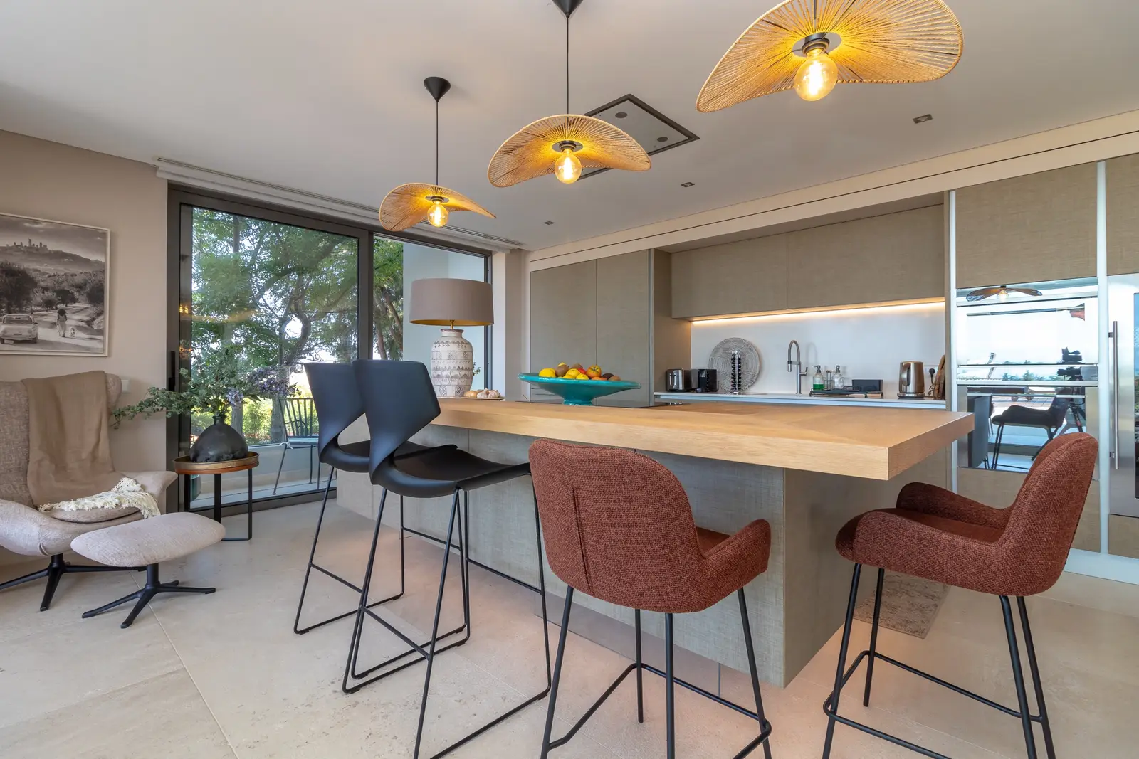 Kitchen island with wooden breakfast bar, black and terracotta bar stools and rattan pendant lights