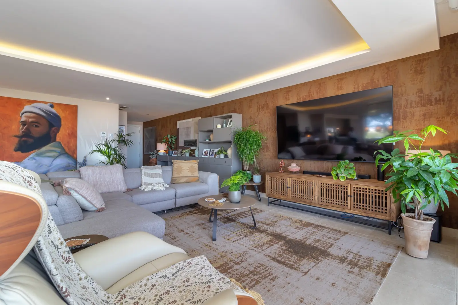Living room with grey sofa, large portrait painting and wooden media unit
